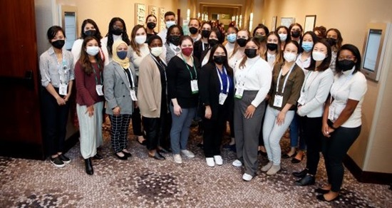 Masked group of Kaiser Permanente Community Health Fellows and Scholars posing in a hallway at APHA's 2022 Annual Meeting